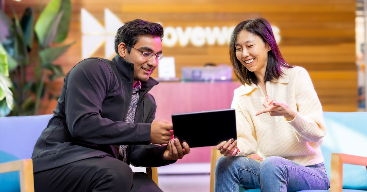 Coworkers holding a tablet discuss workplace search